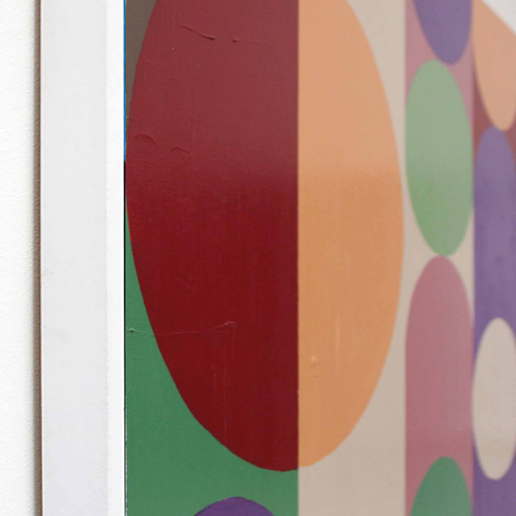 Close-up side view of a framed abstract art painting from AW Modern Art featuring large overlapping circles in red, orange, green, purple, pink, and white on a light background.