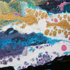Close Up detail of abstract acrylic painting Malva wave with fluid textured splashes of gold, blue, purple, pink, black, and white on a textured canvas.