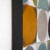 Close-up of an abstract canvas painting featuring a bold mustard yellow oval, a large gray oval, teal and white blocks, and a thick black vertical stripe against a white wall.