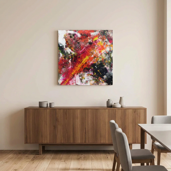 Fire Starter  - A large square abstract canvas painting with vibrant red, orange, yellow, black, and white brushstrokes, displayed on a beige wall above a wooden sideboard in a modern dining room setting.