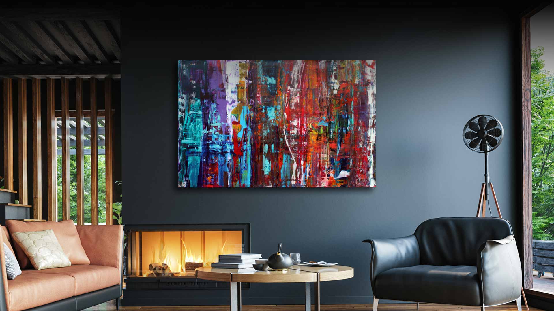 A large rectangular abstract canvas painting with vibrant red, blue, purple, and orange brushstrokes hanging on a dark charcoal wall in a modern living room setting.