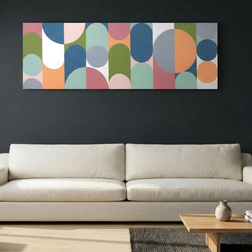 Geo Pop Lines No 8 - A modern living room setting featuring a wide canvas wall art painting with an abstract geometric pattern of colourful arches and circles, hung on a dark charcoal wall above a light beige sofa.