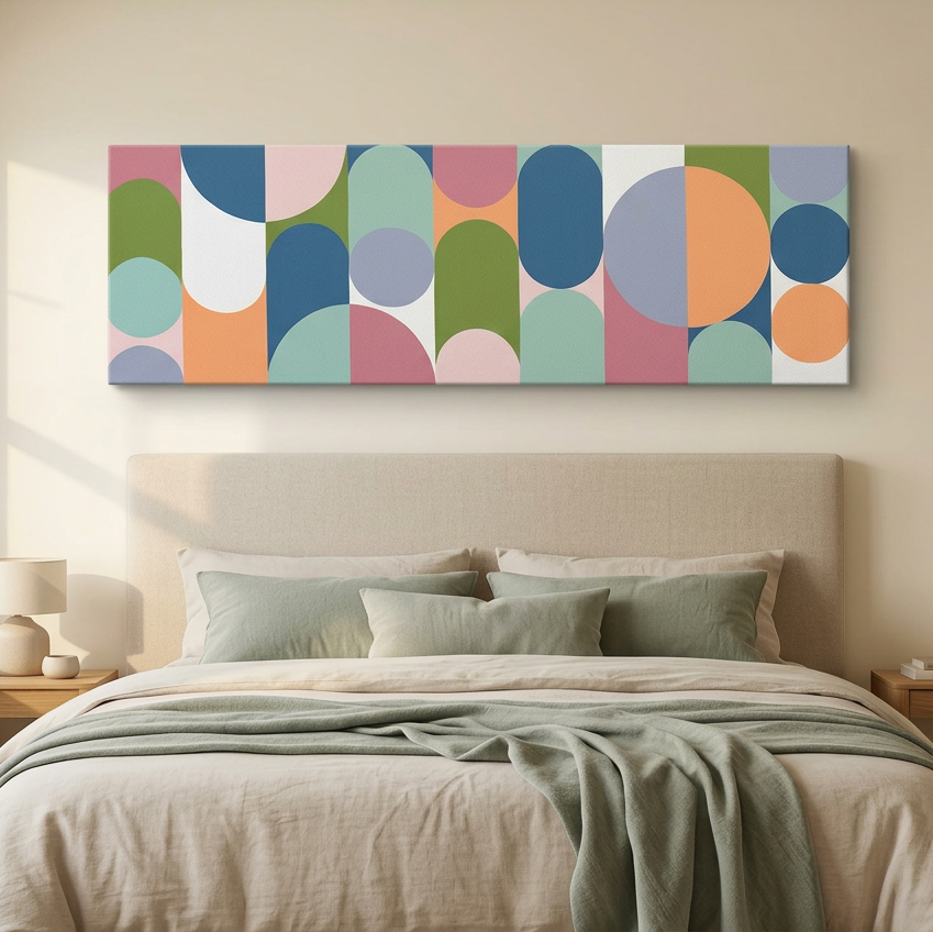 Geo Pop Lines No 8 - A modern abstract wall art painting with colourful geometric shapes hangs above a neatly made bed in a softly lit bedroom. The artwork features overlapping circles and arcs in blue, green, pink, orange, and grey on a white background.