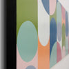 Close-up of a framed abstract art painting featuring pastel geometric shapes including mint green, dusty blue, peach, pink, and white circles on a vertical canvas.