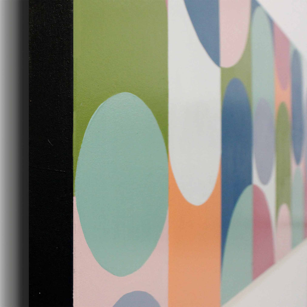 Close-up of a framed abstract art painting featuring pastel geometric shapes including mint green, dusty blue, peach, pink, and white circles on a vertical canvas.
