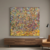 Summer Showers - A large square abstract canvas painting with a dense multi colour confetti pattern hangs on a grey wall above a wooden console table, next to a tan armchair and a black floor lamp.