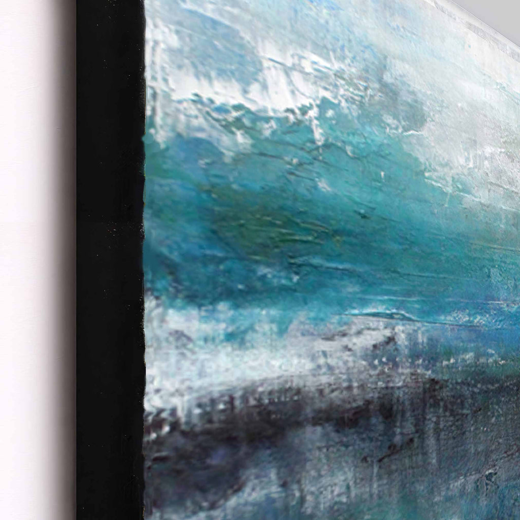 close up detail of abstract framed wall art featuring textured brushstrokes in teal, blue, white, and dark grey, shown with a black frame against a light neutral background.
