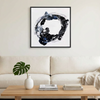 Orbital - A framed abstract wall art painting featuring a black and blue circular brushstroke design on a white background, hanging above a modern beige sofa in a bright, minimalist living room.