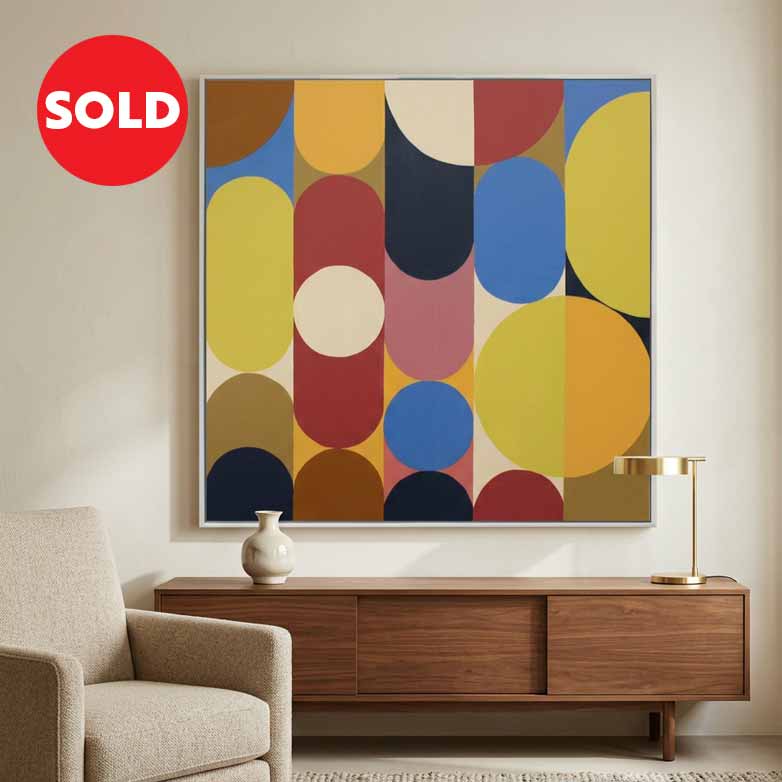 A large square abstract wall art painting with bold geometric circles and arcs in yellow, blue, red, cream, brown, and pink, displayed above a wooden console table in a modern living room. A red circular 'SOLD' badge appears in the top-left corner.