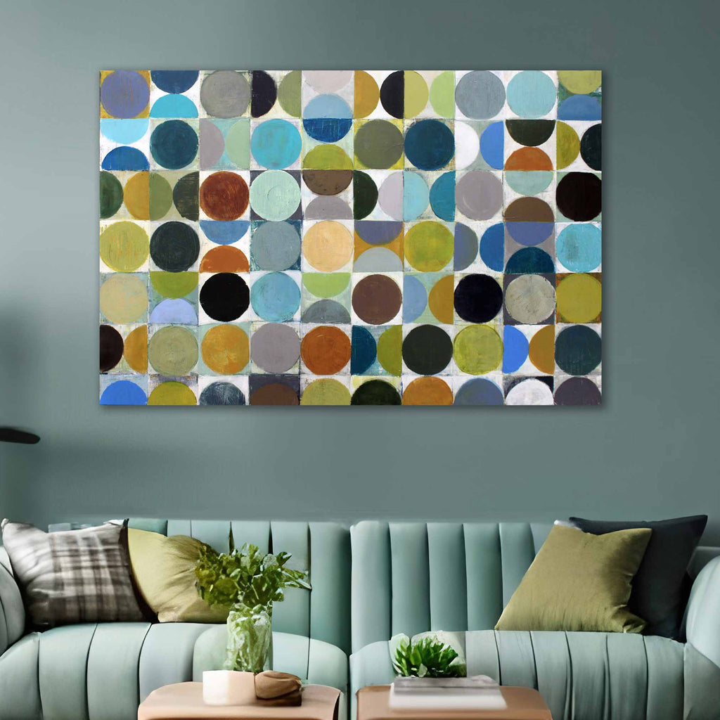 A large rectangular abstract wall art piece with a grid of multicolored circles hangs above a mint green sofa in a styled living room.