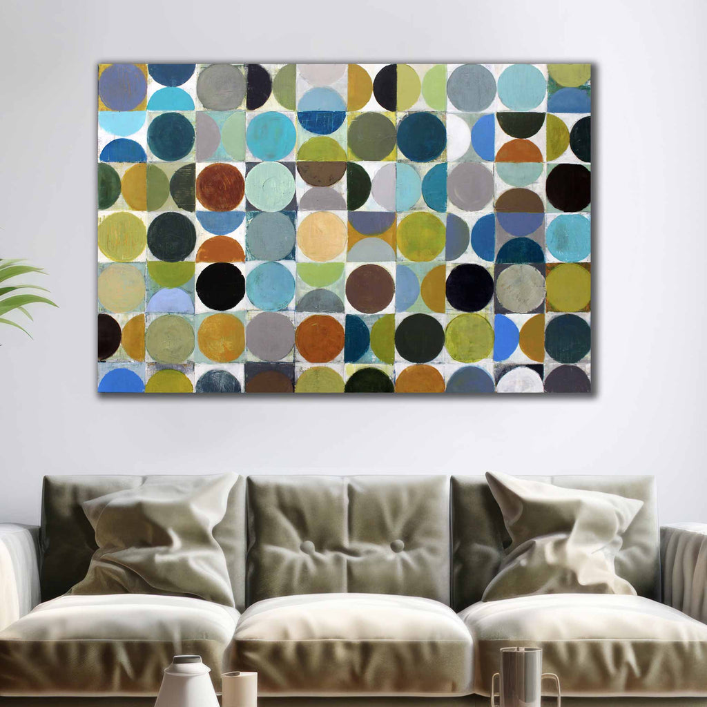 A large rectangular canvas wall art piece featuring an abstract pattern of overlapping circles in multiple colors, displayed above a beige sofa in a modern living room setting.