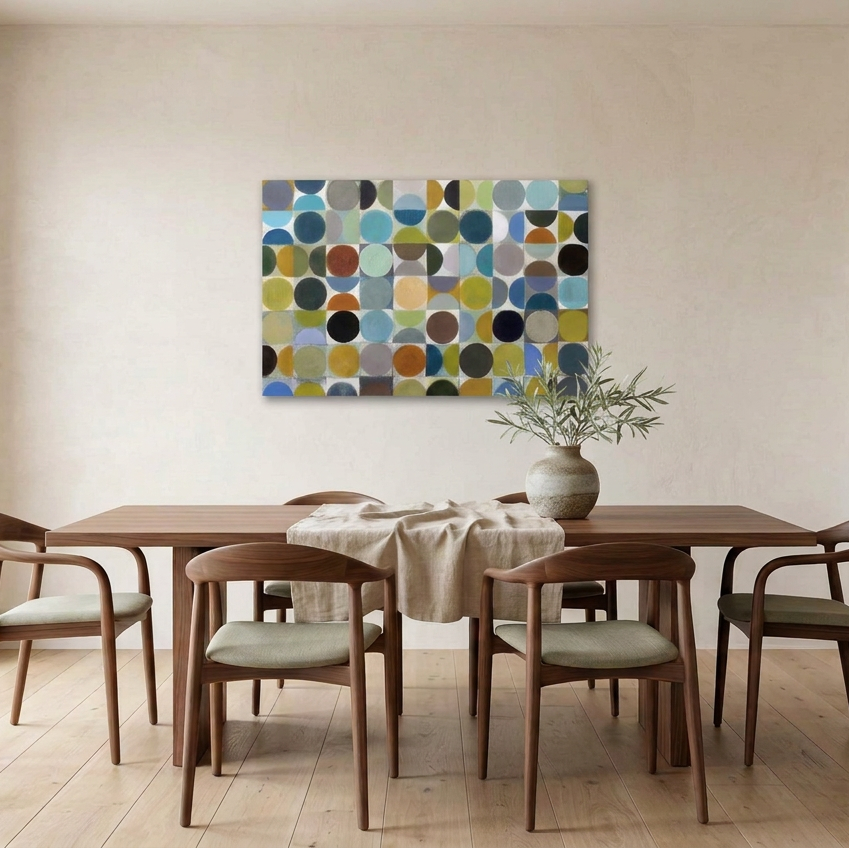 Vintage Spheres No 2 - A large rectangular wall art painting with an abstract pattern of overlapping circles and arcs in blue, teal, olive, mustard, brown, black, and grey, displayed above a wooden dining table with chairs in a bright neutral dining room.