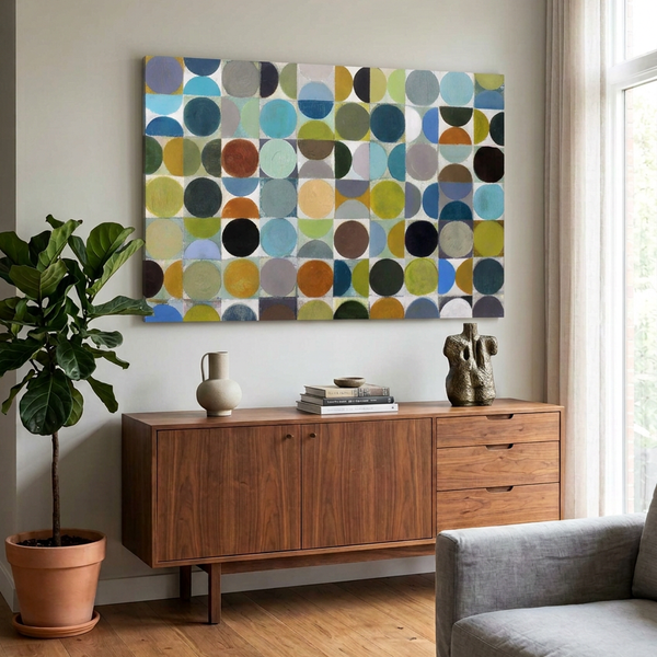 Vintage Spheres No 2 - A large abstract art painting featuring a grid of circles in blues, greys, greens and browns hung on a cream wall in a modern Room Setting, with a wood sideboard underneath.
