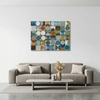 Vintage Spheres 1 - A abstract wall art painting with a grid of multi-coloured circles in blue, teal, green, brown, beige, and grey, displayed above a modern grey sofa in a minimalist living room setting.
