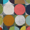 Abstract geometric art painting featuring textured painted circles in coral pink, cream, mustard yellow, green, navy, and teal on a grid background.