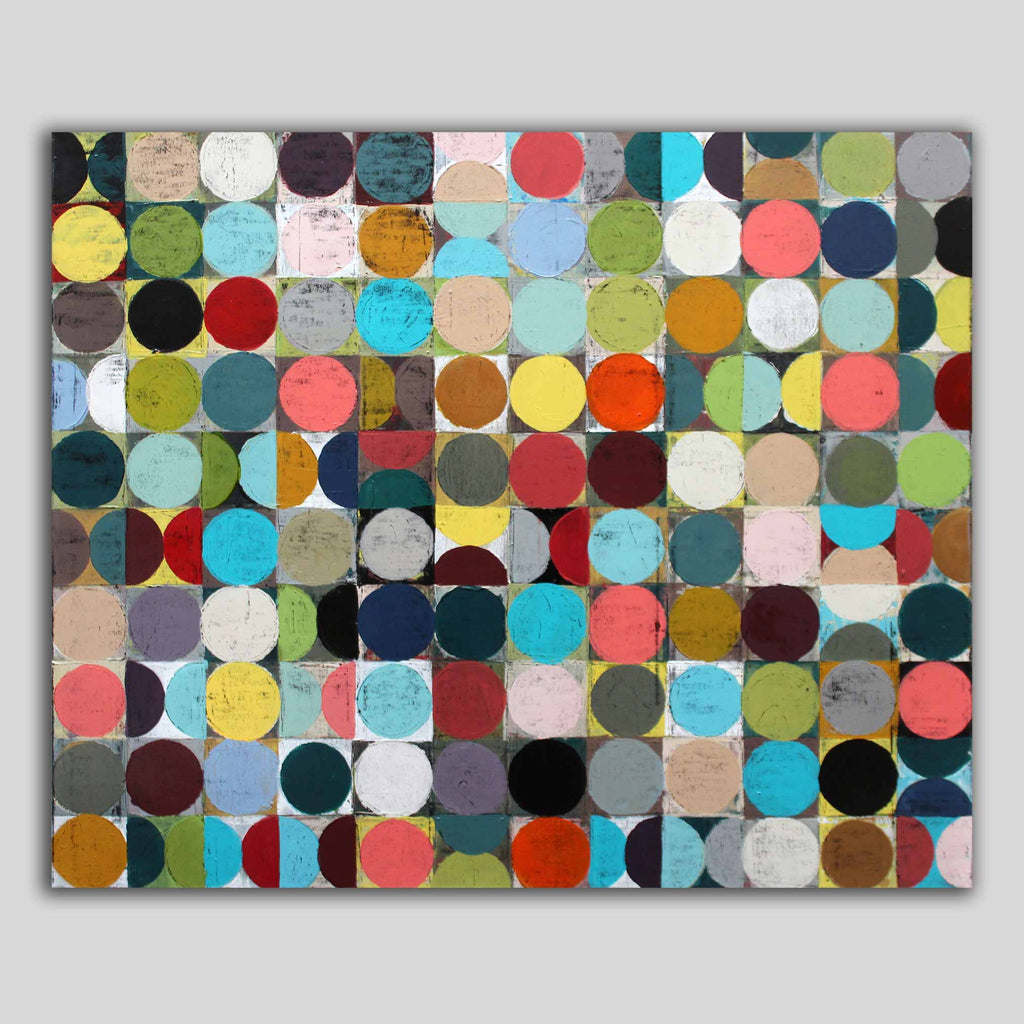 A multi coloured spot abstract canvas painting featuring a grid of vibrant painted circles in multiple colours, hanging against a light grey background.