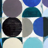 Abstract geometric painting featuring bold painted circles and semicircles in blue, teal, black, grey, taupe, and cream on a white background.