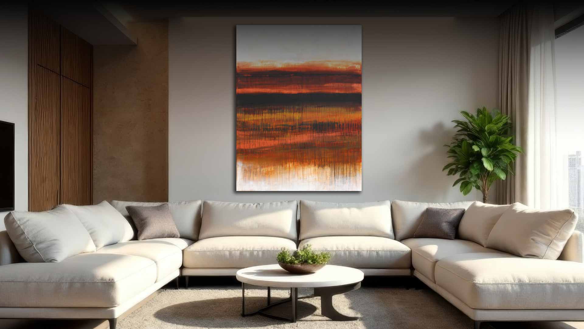 A large vertical abstract canvas print with orange, brown, and black brushstrokes hanging on a gray wall above a modern beige sectional sofa in a styled living room.